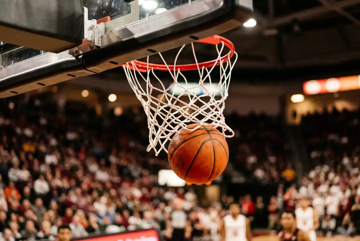 Close-up of an NBA basketball going through the hoop during a game, illustrating scoring outcomes central to spread and totals betting